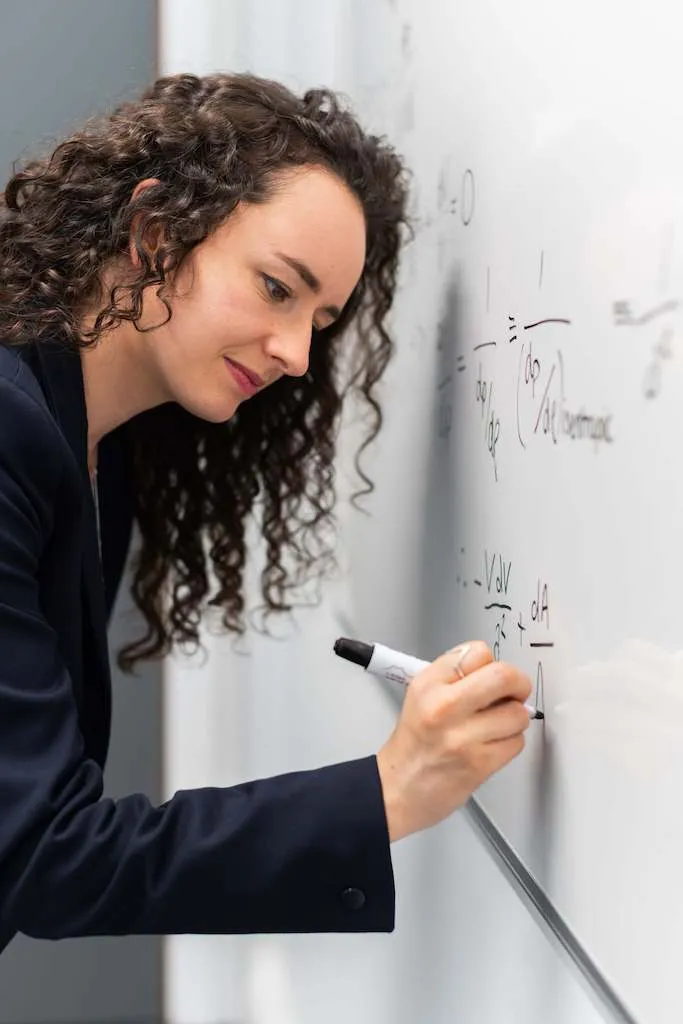 Eine Frau schreibt Notizen an ein Whiteboard